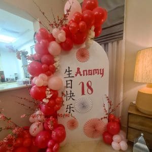 An elegant Asian-inspired birthday balloon decoration featuring red and gold balloons, lantern-shaped balloons, and cultural symbols, creating a festive and sophisticated ambiance.